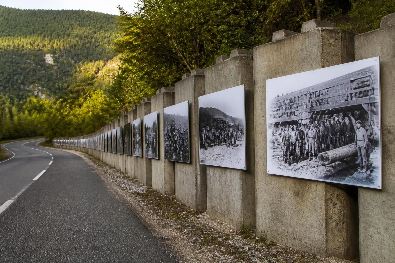 découvrez comment le mur de béton de la d55b au poizat-lalleyriat devient une galerie d'exposition permanente, retraçant l'histoire locale à travers une œuvre artistique unique.